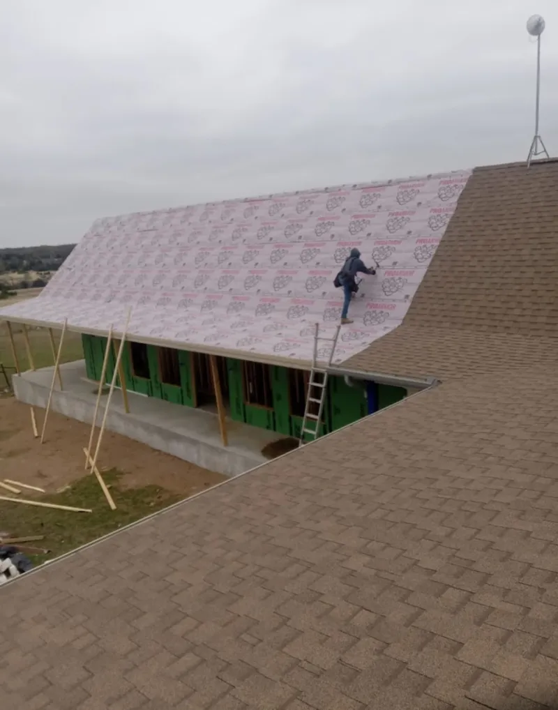 Worker preparing underlayment for a metal roof installation in Black Forest